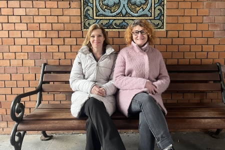 Teamomat: Zwei Frauen sitzen nebeneinander auf einer Bank