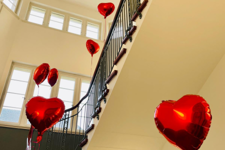 Teamomat: Rote Luftballons in Herzform im Treppenhaus