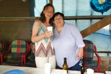 Teamomat: Zwei Frauen Arm in Arm mit Becher in der Hand