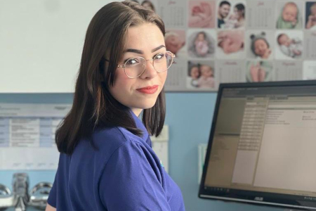 Teamomat: Weibliche Pflegefachkraft mit Brille vor PC