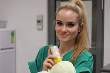 Teamomat: Weibliche Pflegefachkraft mit Baby auf dem Arm