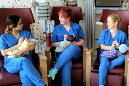 Teamomat: Drei Kolleginnen mit Babys auf dem Arm in Sesseln sitzend