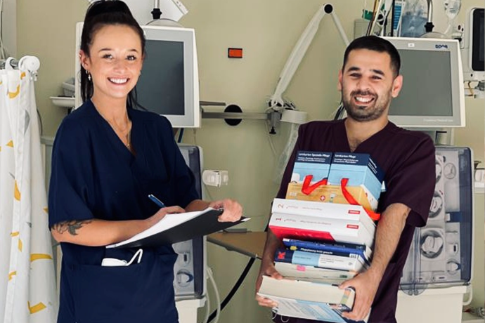 Eine Frau und ein Mann mit einem Stapel Bücher