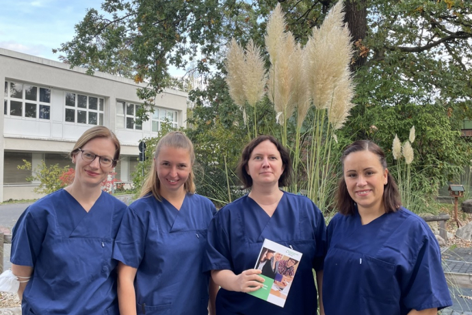 Teamomat: Vier Pflegefachkräfte mit Buch im Freien