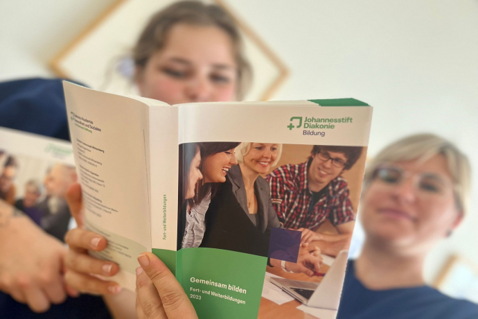 Teamomat: Zwei Pflegefachkräfte schauen in ein Buch