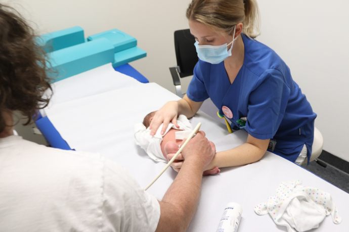 Teamomat: Zwei weibliche Pflegefachkräfte untersuchen Baby